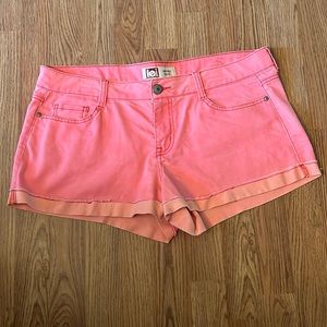 neon peach colored mid-rise jean shorts